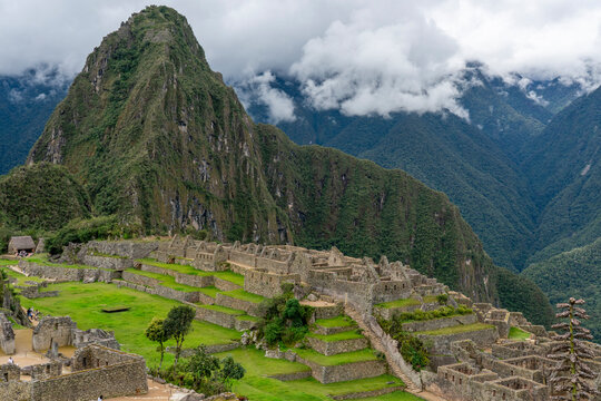 Exploring the ancient ruins of Machu Picchu with mountains and clouds in the background in Peru
