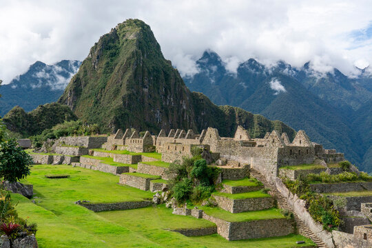 Mountains surround ancient ruins at Inca site of Machu Picchu in Peru with green terraces