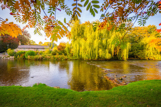 View of Sheepwash Bridge over River Wye with autumn foliage in Derbyshire Dales, England