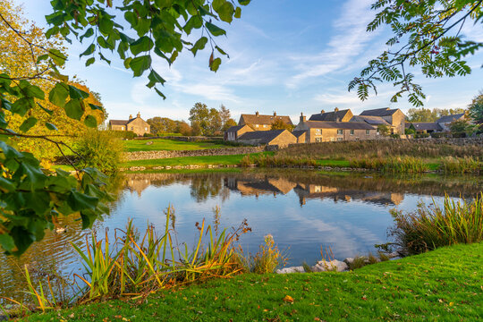 Reflections of Monyash village in a pond during autumn in Bakewell
