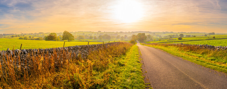 Road leading to Monyash with autumn colors and sunny sky in Bakewell, Derbyshire Peak District, England