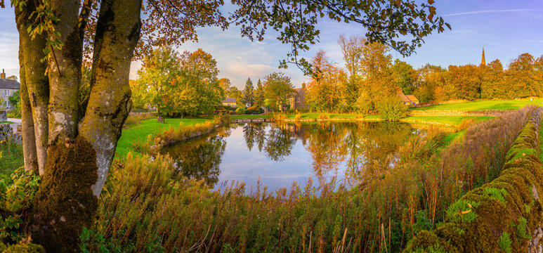Reflections in village pond during autumn in Monyash village, Bakewell, Derbyshire Peak District, England