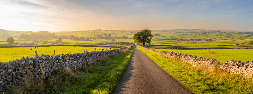 Road through fields leading to Monyash in autumn near Bakewell in Derbyshire Peak District, England, United Kingdom