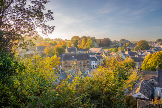 Rooftops of Tideswell during autumn with trees changing colors in the background in Derbyshire Peak District, England