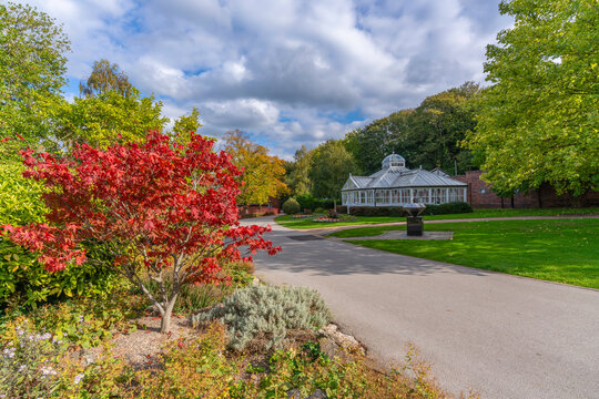View of greenhouse surrounded by autumn trees and paths in Chesterfield, Derbyshire, England
