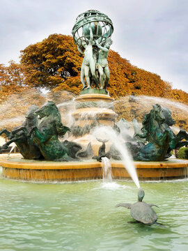 Fountain of the Four Parts of the World shows water spraying over statues in fall season in Paris
