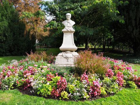 Charles Augustin Sainte Beuve statue in the garden surrounded by flowers in Luxembourg Gardens