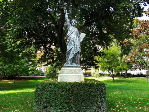 Statue of Liberty stands in the Jardin du Luxembourg surrounded by trees and greenery in Paris during daytime