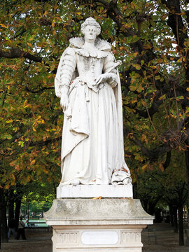 Statue of Marie de Medici stands in the Jardin du Luxembourg surrounded by green trees in Paris