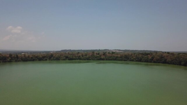 stunning aerial view of a secluded lake, surrounded by a dense forest filled with green algae, remains inaccessible to the locals of Lake Tikub in Tiaong, Quezon, Philippines