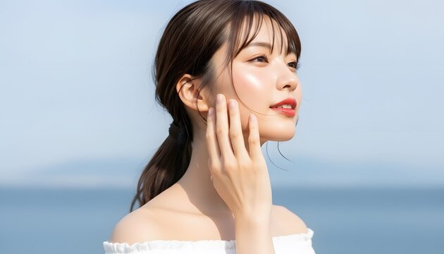 海と青空を背景に透明感のある女性の美容ポートレート