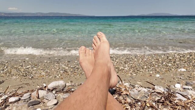 Man sunbathing on a rocky sea ocean beach.
