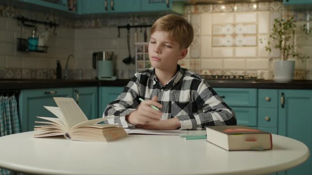 Boy Pausing Homework to Secretly Play on Phone