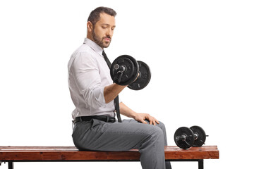 Fototapeta premium Businessman in a shirt and tie lifting a dumbbell on a wooden bench