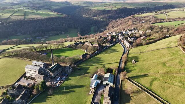 aerial drone view of the village of old town near hebden bridge showing old town mill and houses surrounded by trees and meadows
