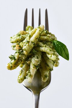 Trofie Pasta with Genovese Basil Pesto Sauce Pine Nuts Fresh Basil Leaf on Silver Fork Italian Macro Photography