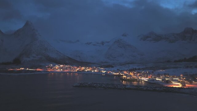 Vuelo lateral sobre pueblo en fiordos noruegos durante hora azul