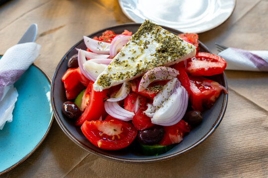 Greek salad with feta cheese slice on a restaurant table.