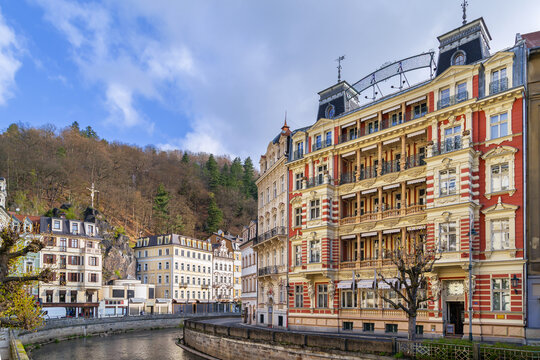 Embankment of Tepla river in Karlovy Vary, Czech Republic. Scenic view of the historic city center. Sunny day with blue sky