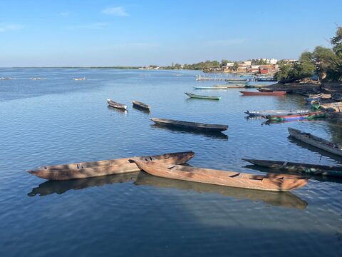 Traditional wooden canoes on Casamance River with Ziguinchor in background