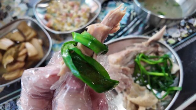 Hands eating chicken wrapped in chives