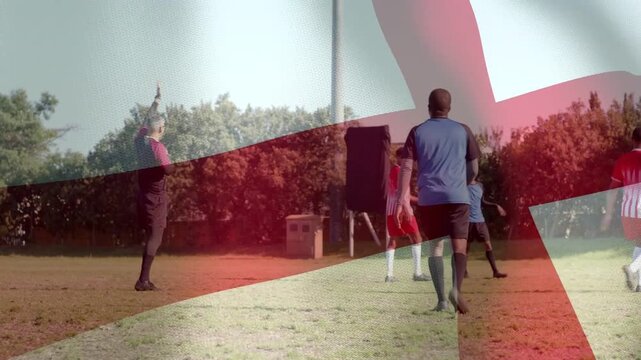 Ref raising arm, signaling pause on sport pitch while players repositioning, flag overlay shifting