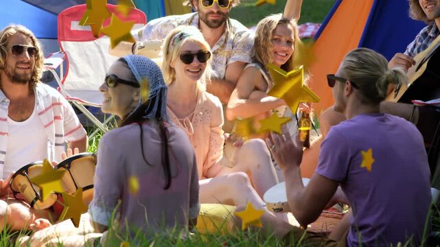 Adult group clapping and playing bongos on grass, clapping causing gold star overlay for marketing