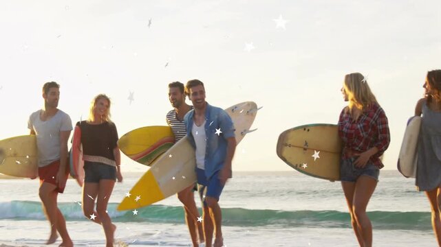 Surf six adults walking to camera on shore, sun causing star overlay over group, adjusting boards