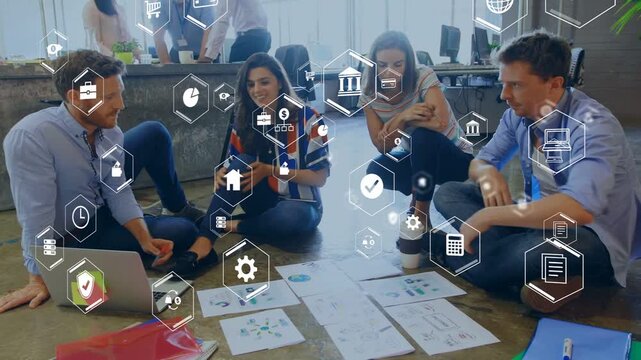 Man tapping laptop causing team on floor sorting charts while AR hex icons guiding design plan