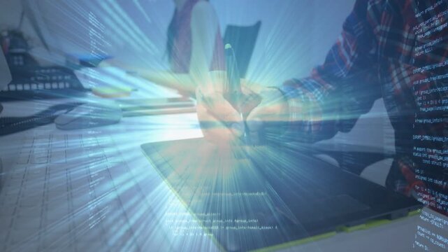 Designer pressing stylus onto graphics tablet, activating blue tech code overlay while drawing UI