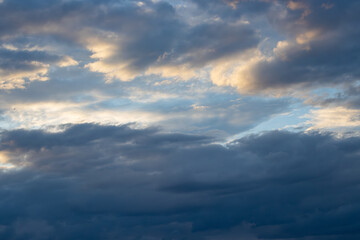 Obraz premium Dramatic Sunset Sky with Golden Sunbeams and Dark Storm Clouds