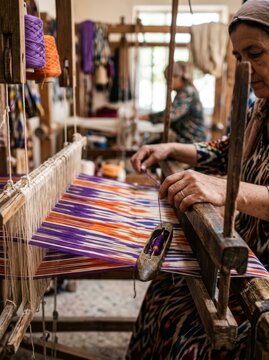 Intricate weaving of traditional Uzbek Adras ikat fabric featuring vibrant silk patterns and manual craftsmanship.
