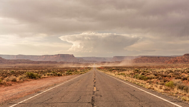 Long Straight Desert Highway in American Southwest Leading Toward Distant Supercell Thunderstorm and Mesas, Travel, Severe Weather, Desert Landscape, Storm Chasing
