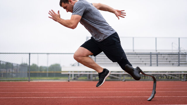 Male Para-Athlete with Prosthetic Running Blade Sprinting on Outdoor Synthetic Track, Adaptive Sport, Inclusive Fitness, Athletics Training, Disability Sport, Para Sport