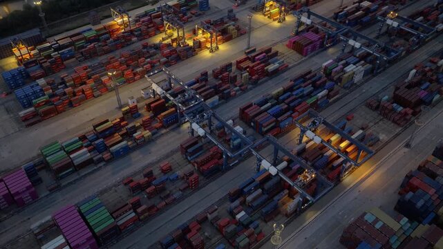 Aerial night view of container handling area with colorful cargo containers and port lights