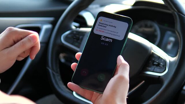 Close-up of a mobile phone showing Scam incoming call and a fraudulent bank alert inside a car. Perfect for educational content about phishing, phone scams, and mobile security. Essential for banking