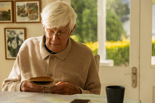 elderly man at home , reading a book