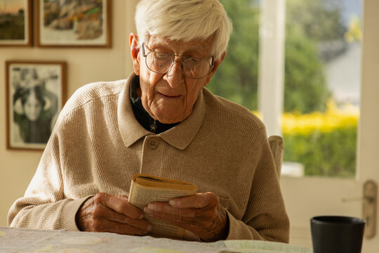elderly man at home , reading a book