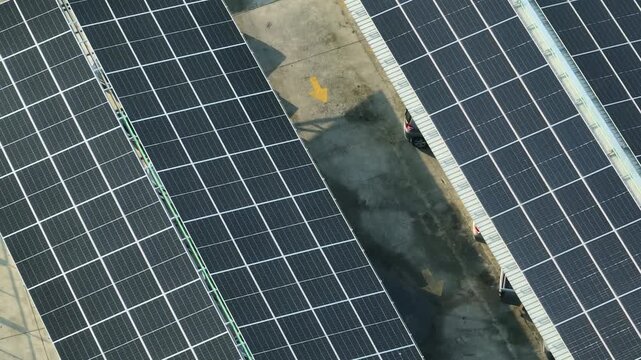 Drone perspective of large solar panel car park roof, showing sustainable energy harvesting, CO2 reduction, efficient land use, and future-ready green infrastructure development. 4k.
