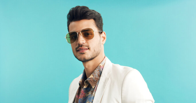 Man, portrait or retro fashion with sunglasses in studio for old style or trend on a blue background. Male person, vintage or stylish outfit with shades for swag, nostalgic look or throwback on space