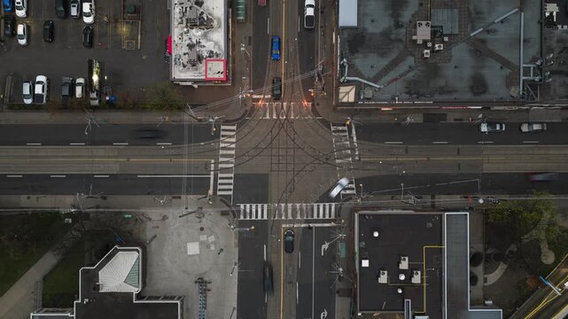 Dynamic Toronto streetcar turning at urban intersection during evening rush hour, with car traffic moving fast through city street creating light trails hyperlapse