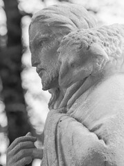 Naklejka premium Black and white statue of Jesus Christ carrying lost sheep