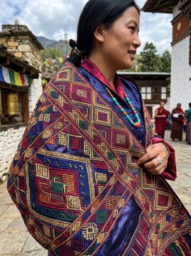 Detailed view of a traditional Bhutanese Kira featuring intricate silk weaving and supplementary warp patterns.