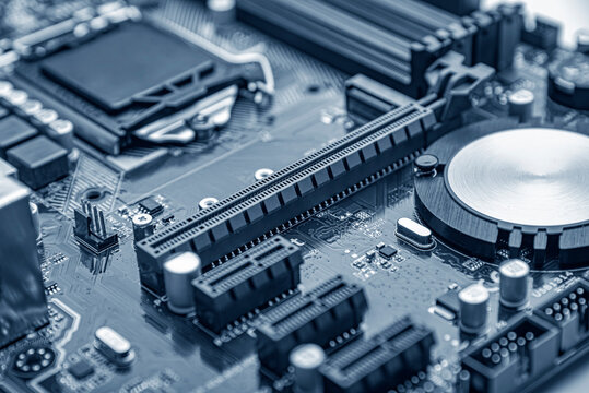 The intricate details of a blue-toned computer motherboard with various electronic components and slots.