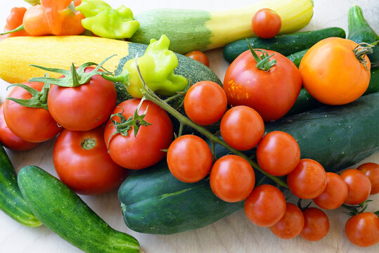 Mixed tomatoes, cucumbers, peppers, and zucchini arranged in bright composition. Reflects everyday healthy cooking ingredients, Mediterranean diet inspiration, and fresh seasonal produce abundance.