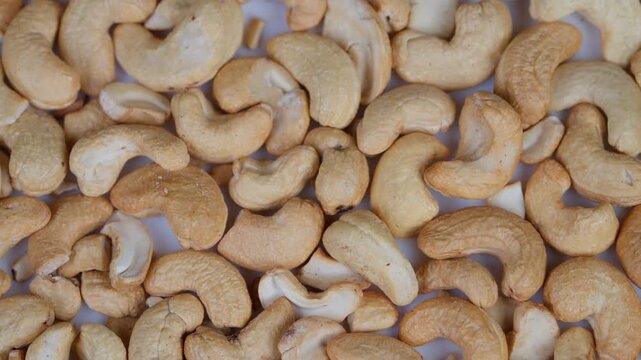 Closeup roasted cashews. Topdown view of crispy roasted cashews with salt crystals. Closeup image of roasted cashew nuts with salted crunch and natural appeal for packaging