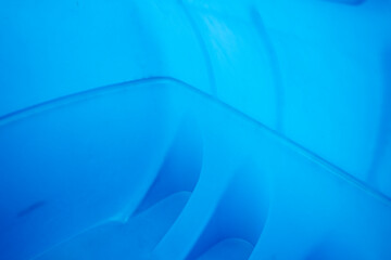 Naklejka premium Close up of blue plastic water tank interior with curved molded walls, showing empty storage container surface and abstract texture.