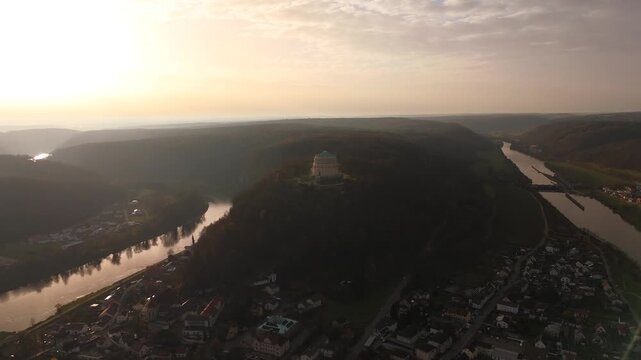 Aerial View der Befreiungshalle in Kelheim, Niederbayern, Deutschland, gelegen auf dem Michelsberg mit Blick auf Donau, Altmuehltal und umliegende Berglandschaft im warmen Licht des Sonnenuntergangs.