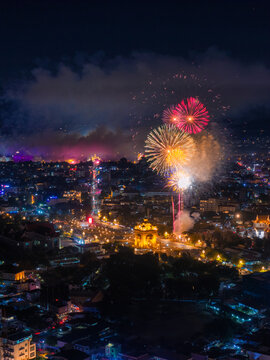 Stunning aerial night view of colorful fireworks exploding over Patuxai Victory Monument in Vientiane, Laos.