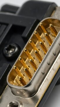 Macro shot of a gold-plated D-sub connector with pins and a black plastic housing